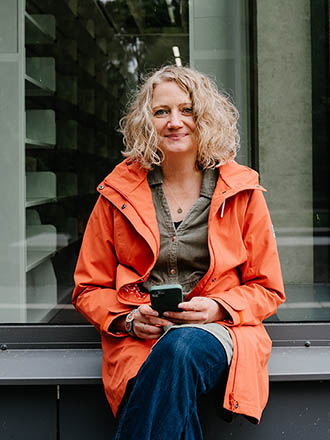 Ein Porträt von Sylvia Paproth mit Smartphone