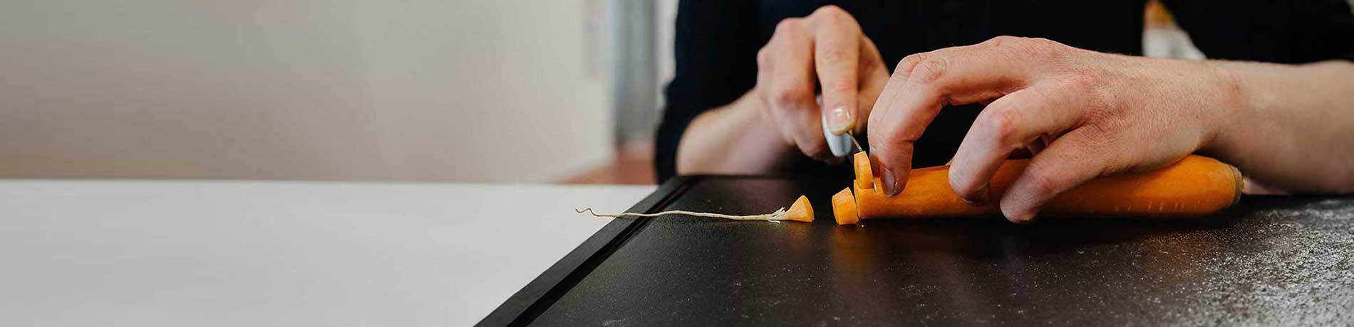 Eine Karotte wird in Scheiben geschnitten